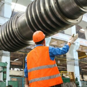A safety leader guiding his team in industrial area to handle heavy equipment.