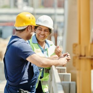 A crew leader and construction worker talking at job site.