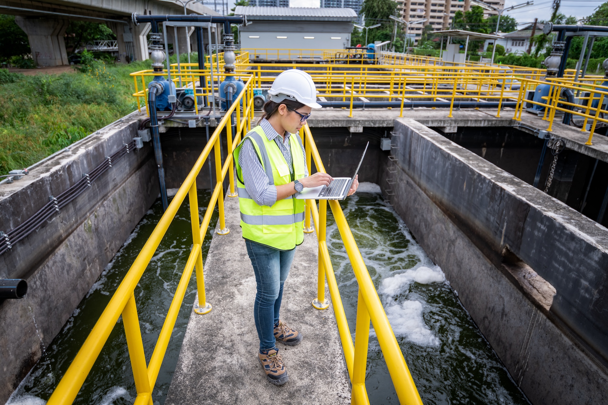 Woman in safety vest with clip board reviewing water