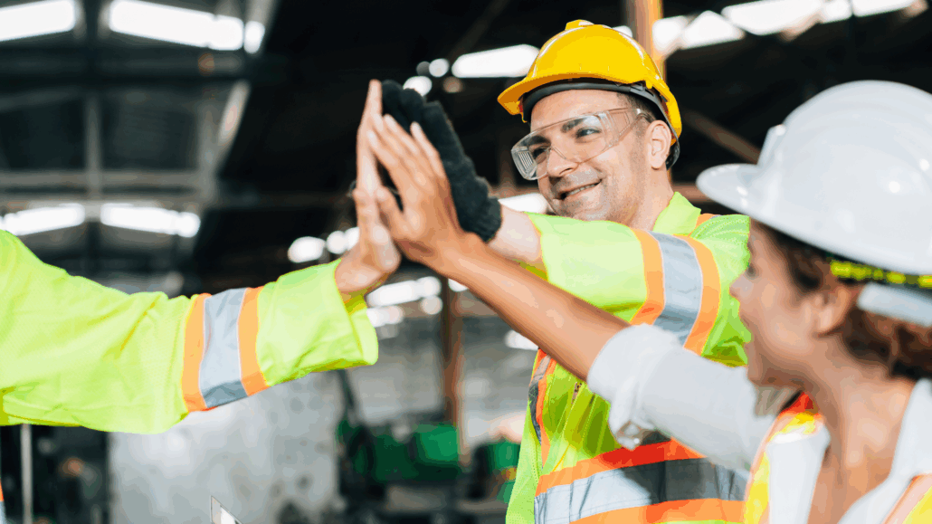 Industrial workers giving high five together